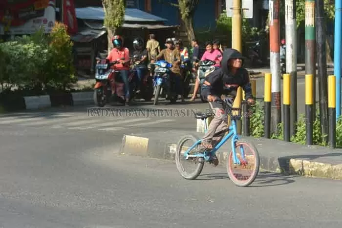 CUEK: Anak-anak bersepeda di Jalan RE Martadinata tanpa mengenakan masker. Ini bukan pemandangan langka di Banjarmasin. | Foto Wahyu Ramadhan/Radar Banjarmasin