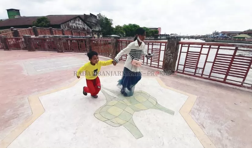 MOTIF KETUPAT: Anak-anak bermain di Siring Sungai Baru, Banjarmasin Tengah, kemarin (28/10). Kawasan ini terkenal dengan julukan Kampung Ketupat. | FOTO: WAHYU RAMADHAN/RADAR BANJARMASIN
