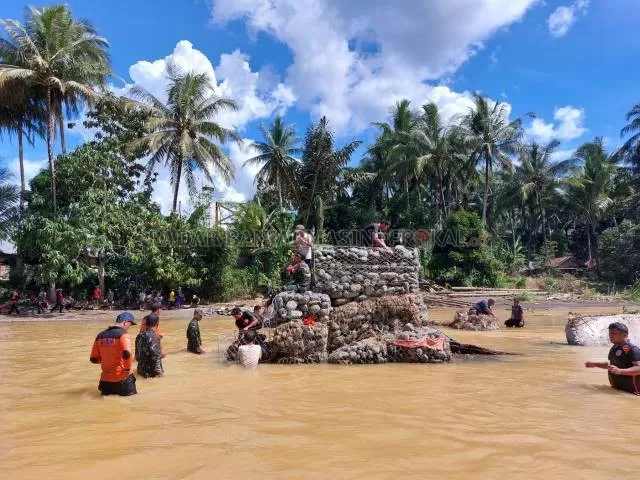 HANYUT LAGI: Warga gotong royong kembali membangun pondasi jembatan darurat di Desa Alat, Kecamatan Hantakan, Minggu (21/11). | FOTO: JAMALUDDIN/RADAR BANJARMASIN