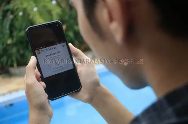DIKELUHKAN: Seorang warga menunjukkan status blanko KTP kosong di Disdukcapil Banjarbaru. | Foto: Muhammad Rifani/Radar Banjarmasin
