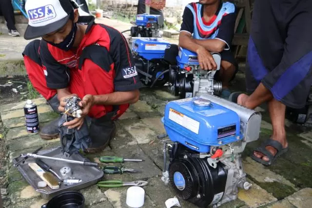 BERSIHKAN: Mesin milik nelayan Desa Telaga Langsat sedang dilakukan servis.
