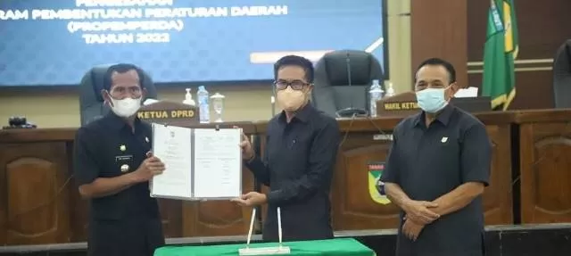 PERLIHATKAN : Bupati Tala HM Sukamta bersama Ketua DPRD Tala Muslimin dan Wakil Ketua DPRD Atmari menunjukkan penandatanganan penetapan Propemperda 2022 di Ruang Sidang DPRD Tala, Rabu (24/11).
