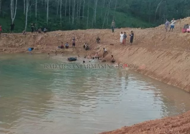 EVAKUASI: Warga sedang mencari Nusaibah, bocah Desa Tajau Mulya yang tenggelam di embung desa yang baru selesai dibangun.