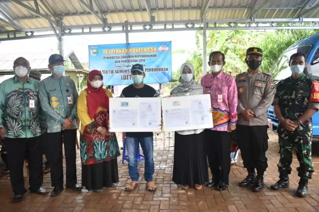BERSAMA: Bupati Tala HM Sukamta foto bersama dengan warga setelah monitoring pelayanan diberikan Disdukcapil Tala pada kegiatan Manunggal Tuntung Pandang (MTP) di Desa Handil Birayang Bawah, Jumat (26/11).