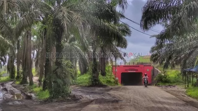 TIMPANG: Jalan tambang di Kecamatan Angsana menjadi potret buram pertambangan di Tanah Bumbu, truk terbuka lewat atas sementara warga lewat di bawahnya. | FOTO: ZALYAN SHODIQIN ABDI/RADAR BANJARMASIN