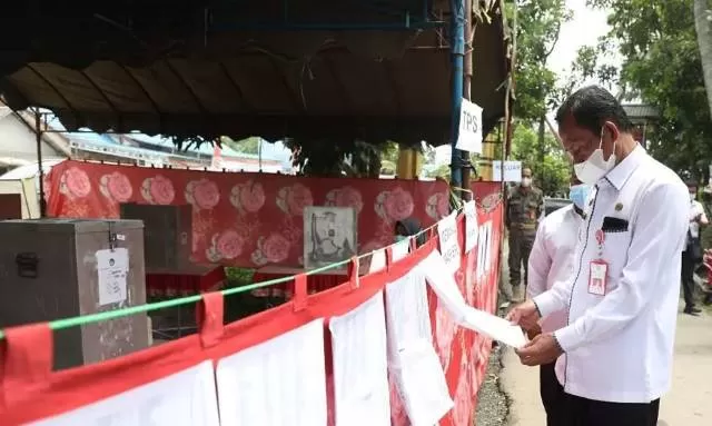 KELILING: Bupati Tala HM Sukamta memeriksa daftar pemilih tetap di salah satu TPS di Kecamatan Tambang Ulang.