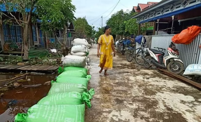BASAH : Warga Ulu Benteng bersiap menjemur padi mereka yang basah terendam banjir rob akibat air pasang.
