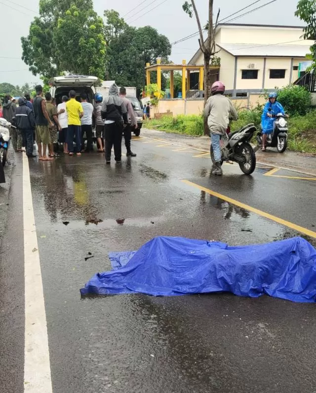 EVAKUASI: Warga mengevakuasi korban kecelakaan di ruas Jalan A Yani Km 50 Desa Tambang Ulang, Tanah Laut, Selasa (14/12).