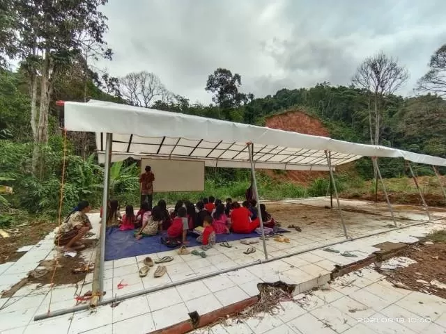 BELAJAR DI TENDA: Para siswa SDN 3 Haruyan Dayak saat mengikuti proses belajar di dalam tenda darurat beralas terpal. Bangunan sekolah mereka hancur akibat disapu banjir dan longsor Januari 2021 tadi. | Foto: Lina Erma Yanti For Radar Banjarmasin