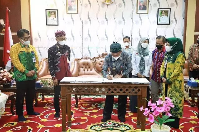 TERIMA: Bupati Tala HM Sukamta menandatangi naskah perjanjian hibah barang milik negara dari KPU Kabupaten Tala.