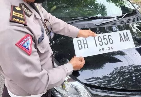 BELUM TANGGALNYA: Polisi menilang pengendara pelat putih di Jambi. Sebelum tanggal penerapannya, pengunaan pelat putih bakal ditilang. | FOTO: IST
