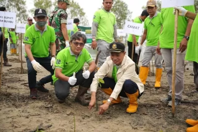 PEDULI: Sekda Pemkab Tanbu Ambo Sakka (kanan) menanam pohon bakau pada peringatan Hari Lingkungan Hidup Sedunia, Sabtu (18/6).