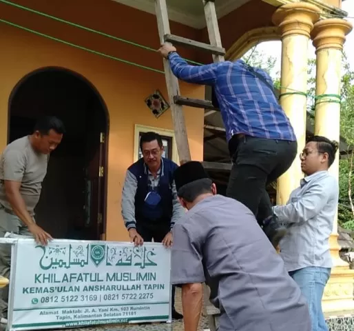 COPOT LAGI: Kesbangpol Tapin bersama petugas gabungan saat mencopot plang Khilafatul Muslimin yang terpasang kembali di rumah Akmad Junaidi.