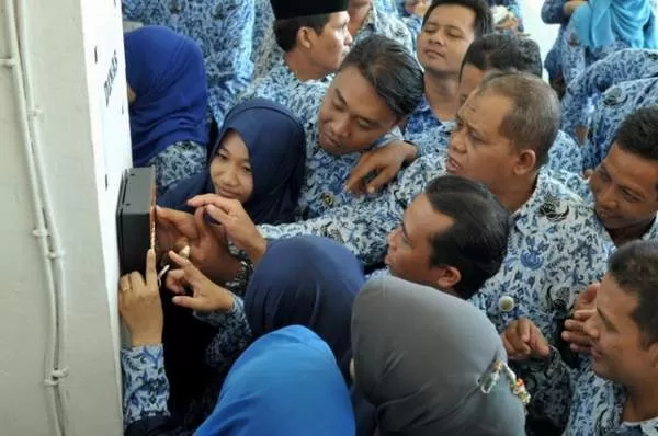 SIDIK JARI: PNS Pemko Banjarmasin berebut memencet mesin absensi sidik jari. Foto diambil di Balai Kota, sebelum pandemi. FOTO: MUHAMMAD SYARAFUDDIN/RADAR BANJARMASIN