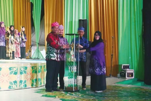 PRESTASI: Bupati Tala HM Sukamta didampingi Wakil Bupati Tala Abdi Rahman dan Ketua LPTQ Tala H Dahnial Kifli menyerahkan piala bergilir Juara Umum kepada Camat Pelaihari Rika Amalia.