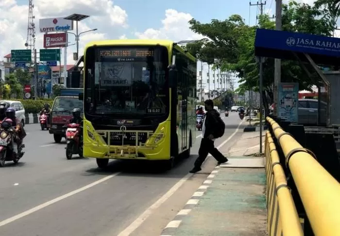 NAIK BUS: Penumpang naik bus Trans Banjarbakula dari halte di Jalan Ahmad Yani km 3,5 seberang Mapolresta Banjarmasin. FOTO: WAHYU RAMADHAN/RADAR BANJARMASIN