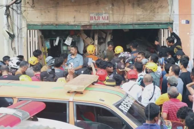 RAMAI: Warga berikut relawan merubung lokasi ambruknya bagian dalam toko di kawasan Pasar Baru, Selasa (27/9). FOTO: WAHYU RAMADHAN/RADAR BANJARMASIN