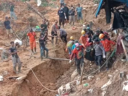 KANTONG MAYAT: Tim pencari mengevakuasi korban yang tertimbun tanah longsor di tambang emas tradisional di Kotabaru.