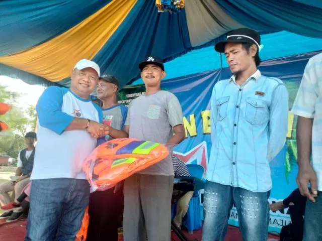 UPAYA: Pemkab Tanah Bumbu membagikan jaket pelampung dan alat kebersihan kepada nelayan di Pagatan saat menggelar gotong-royong.