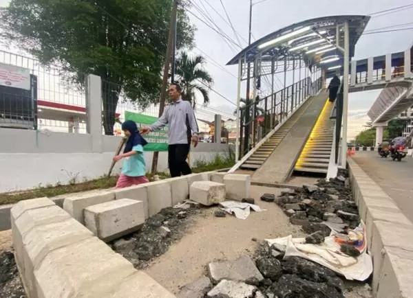 ANTI PEMOTOR: Dinas PUPR Kota Banjarbaru memasang trotoar di area akses naik atau turun JPO Banjarbaru. Sekarang pengunci trotoar atau kanstin telah disusun, kemudian baru ditimbun tanah dan dipasang paving trotoarnya. | FOTO: M RIFANI/RADAR BANJARMASIN