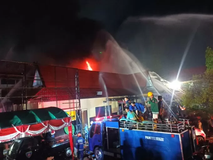 SI JAGO MERAH: Relawan damkar berjibaku memadamkan api yang melahap lantai dua gedung Biro SDM Polda Kalsel. | FOTO: M FADLAN ZAKIRI/RADAR BANJARMASIN