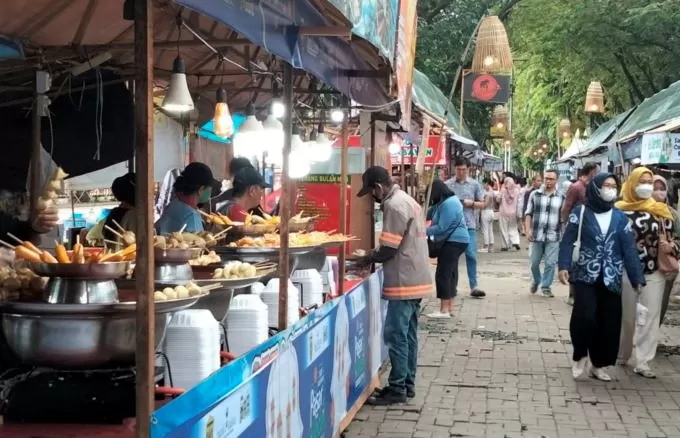 TENTENG KOTAK: Pengamen berkeliling di kawasan Pasar Wadai Ramadan di Siring Menara Pandang, kemarin (24/3). | FOTO: WAHYU RAMADHAN/RADAR BANJARMASIN