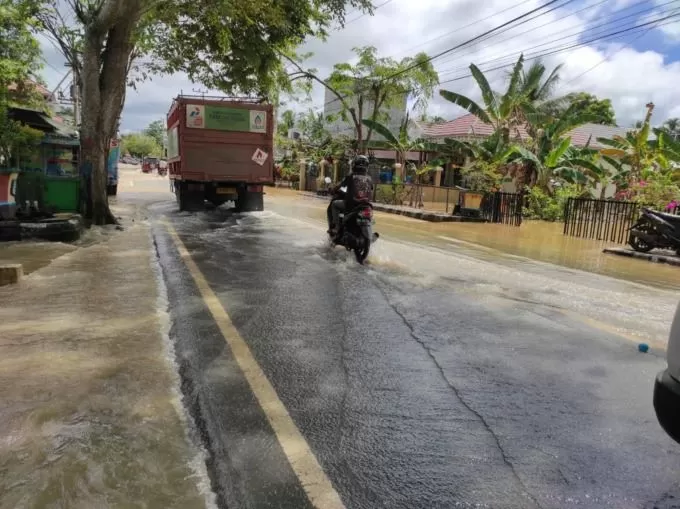 MASIH TERGENANG : Jalan di Pihaung Parincahan, Kecamatan Kandangan masih tergenang saat dilintasi pengendara. : FOTO SALAHUDIN/RADAR BANJARMASIN.