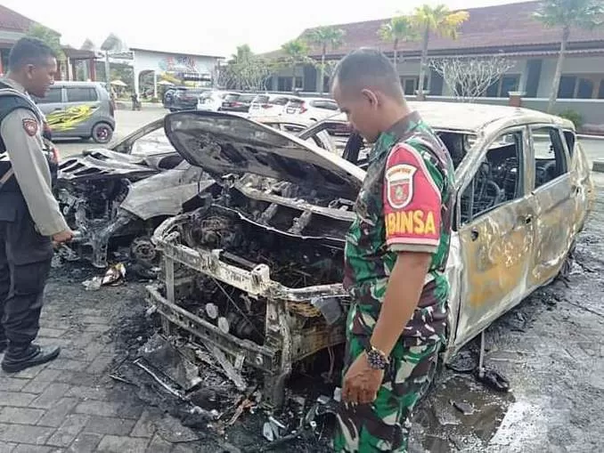 BANGKAI MOBIL: Anggota TNI dan Polri memeriksa bangkai mobil yang terbakar di halaman parkir The Breeze. | FOTO: PUTU SUKAWIDANA FOR RADAR BJM