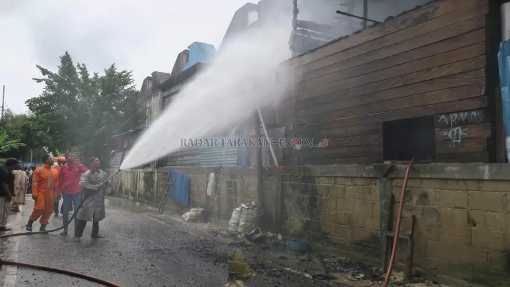 DIPADAMKAN: Petugas PMK berusaha memadamkan api yang membakar tempat usaha pemotongan ayam di Gusher, Jalan Gajah Mada, Tarakan Barat, kemarin (13/1).