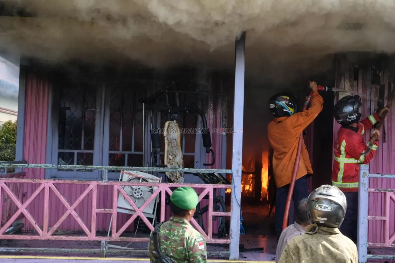 TERBAKAR: Petugas dari pemadam kebakaran dibantu anggota TNI dan Polri saat memadamkan api di rumah warga RT 13, Jl. Swadaya, Desa Malinau Kota, Selasa (28/1). FOTO: AGUSSALAM SANIP/RADAR TARAKAN