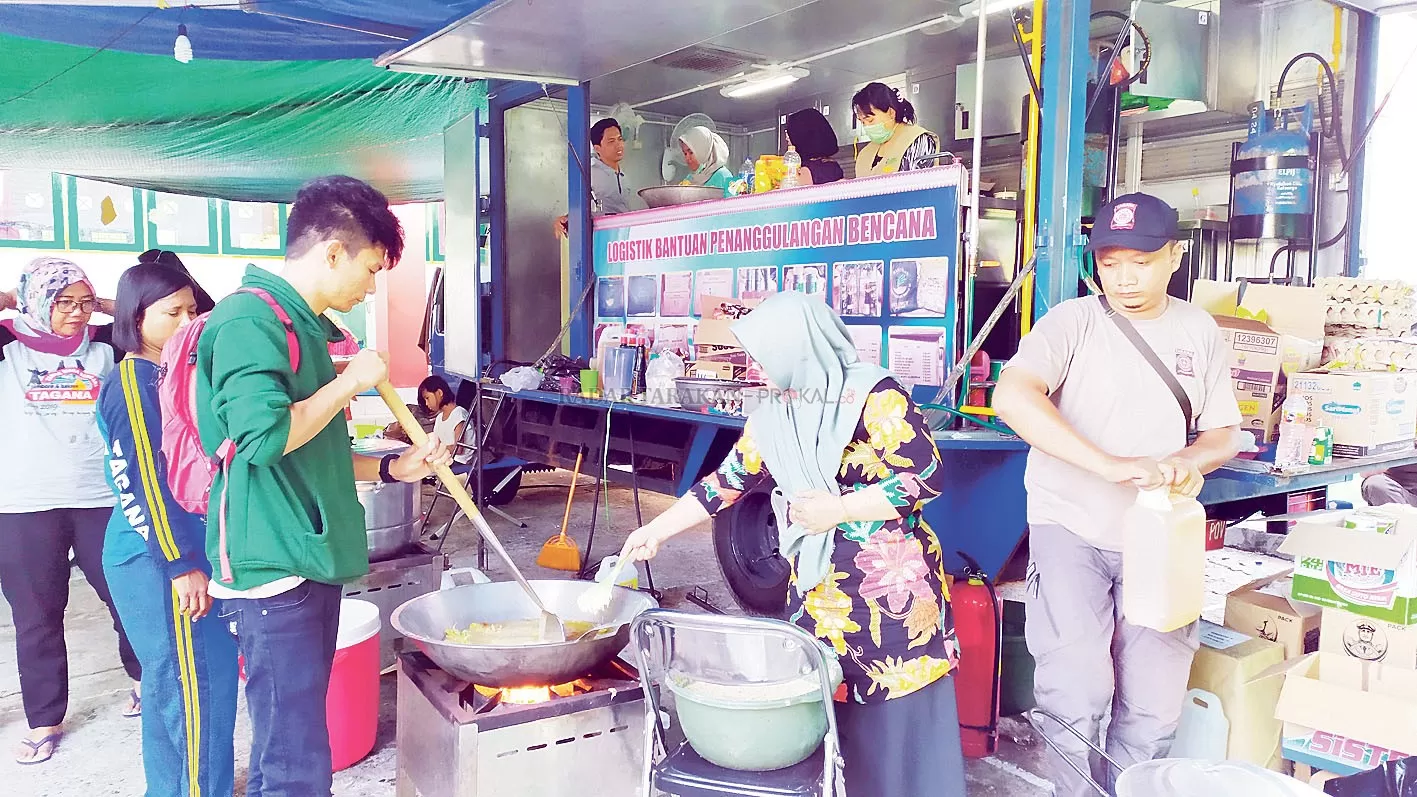 GOTONG ROYONG: Suasana dapur umum di posko tanggap darurat, Rabu (29/1). Bahu membahu memasak untuk 520 jiwa korban kebakaran Pasar Batu.