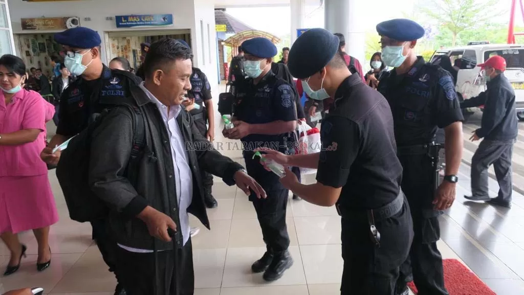 CEGAH CORONA : Sejumlah penumpang yang baru tiba di Tarakan diminta membersihkan tangan oleh petugas Satbrimob Polda Kaltara, kemarin (13/3).