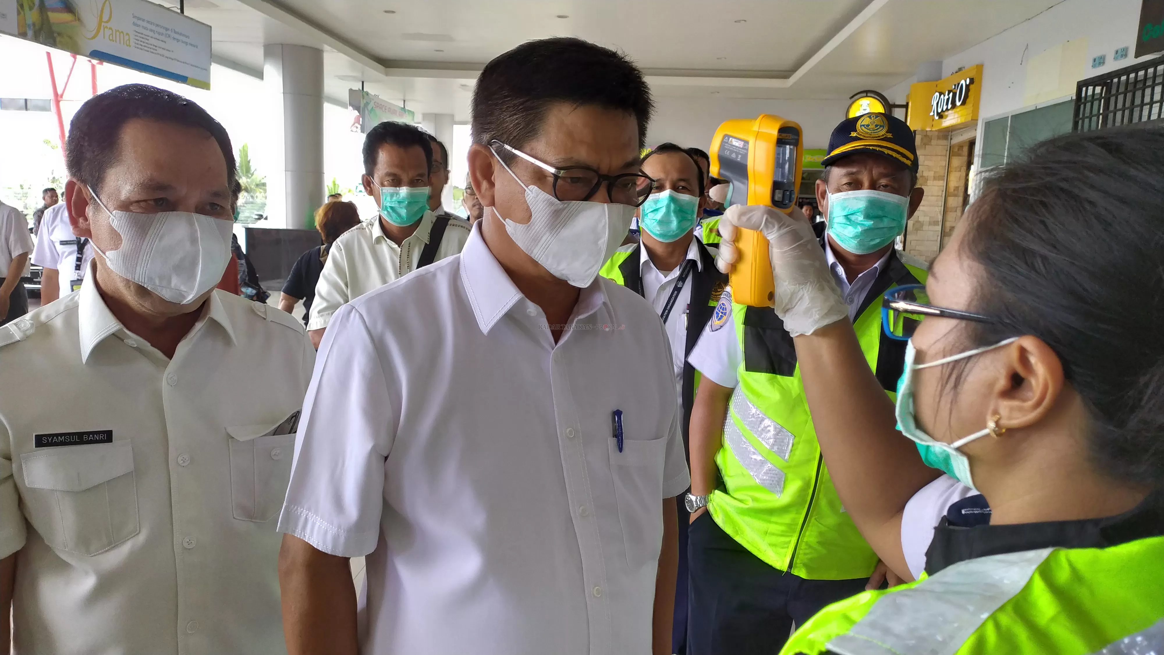 CEK KESIAPAN: Seorang petugas kesehatan memeriksa suhu tubuh Gubernur Kaltara Dr. H. Irianto Lambrie yang melakukan inspeksi ke Bandara Juwata Tarakan, kemarin (18/3).