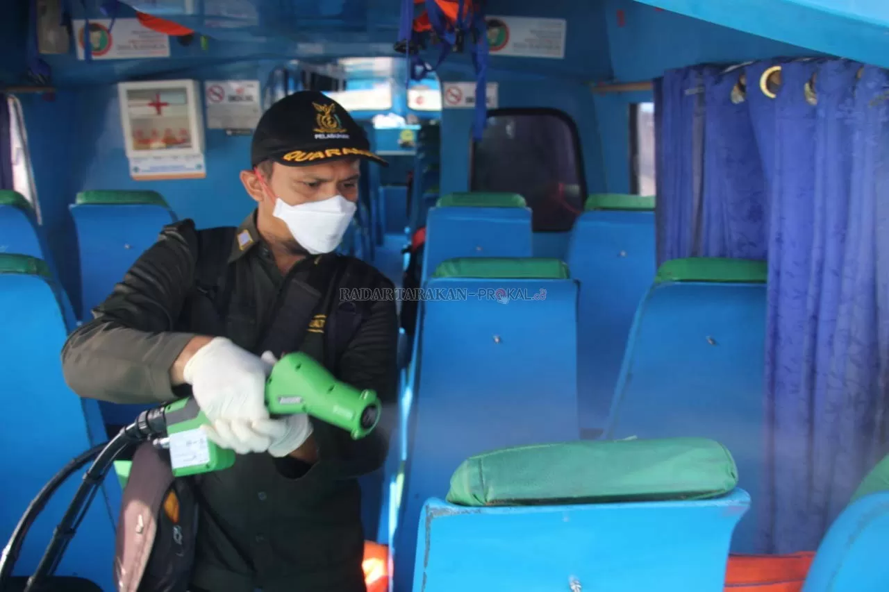 SETRILISASI: Petugas melakukan penyemprotan cairan pembunuh bakteri di dalam speedboat reguler yang baru nyandar di Dermaga Kayan II Tanjung Selor kemarin.