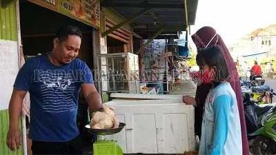 KELUHKAN: Salah satu penjual ayam potong di Jalan Jenderal Sudirman terlihat melayani pembeli, Selasa (19/5).