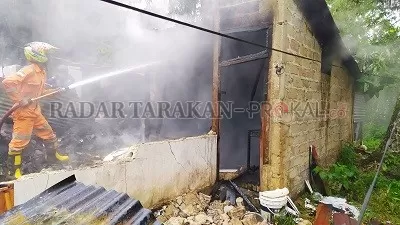 JADI ARANG: Petugas ketika memadam sisa-sisa api yang menghangus satu unit rumah di Kelurahan Juata Laut, kemarin (28/5)./FOTO IFRANSYAH/RADAR TARAKAN