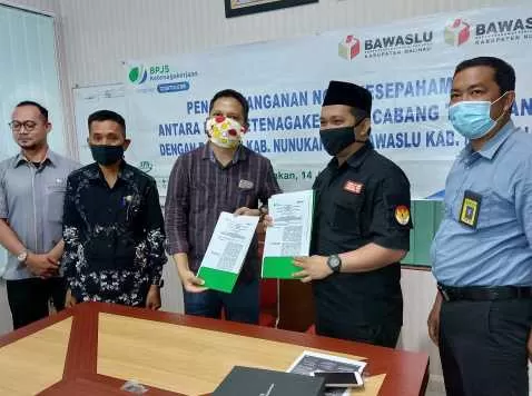 MOU: Kepala BPJAMSOSTEK Kantor Cabang Tarakan, Wira Siraiy (3 dari kanan) dan Ketua Bawaslu Mochammad Yusrah (dua dari kanan) menunjukkan berkas Mou yg telah ditandatangani kedua belah pihak. FOTO: IST