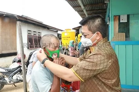BLUSUKAN: Dr. H. Irianto Lambrie memasangkan masker kepada masyarakat./AGUS DIAN ZAKARIA/RADAR TARAKAN