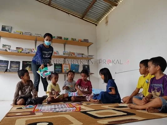 BELAJAR BERSAMA: Sejumlah anak-anak Kampung Timur belajar bersama di perpustakaan mini yang dibangun di Kampung Timur, Nunukan Barat./RIKO ADITYA/RADAR TARAKAN