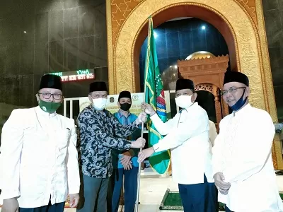 SIMBOLIS: Wakil Bupati Nunukan H. Hanafiah, menyerahkan bendera pataka kepada  Ketua Umum LPTQ Kabupaten Nunukan Muhammad Amin. Sebagai tanda pelepasan kafilah Nunukan./DOKUMENTASI PEMKAB NUNUKAN