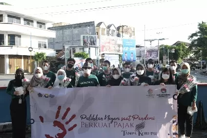 PERINGATI HARKODIA: Pegawai KPP Pratama Tanjung Redeb saat melakukan aksi simpatik dengan turun ke jalan membagikan souvenir seperti bunga dan masker kepada masyarakat. 