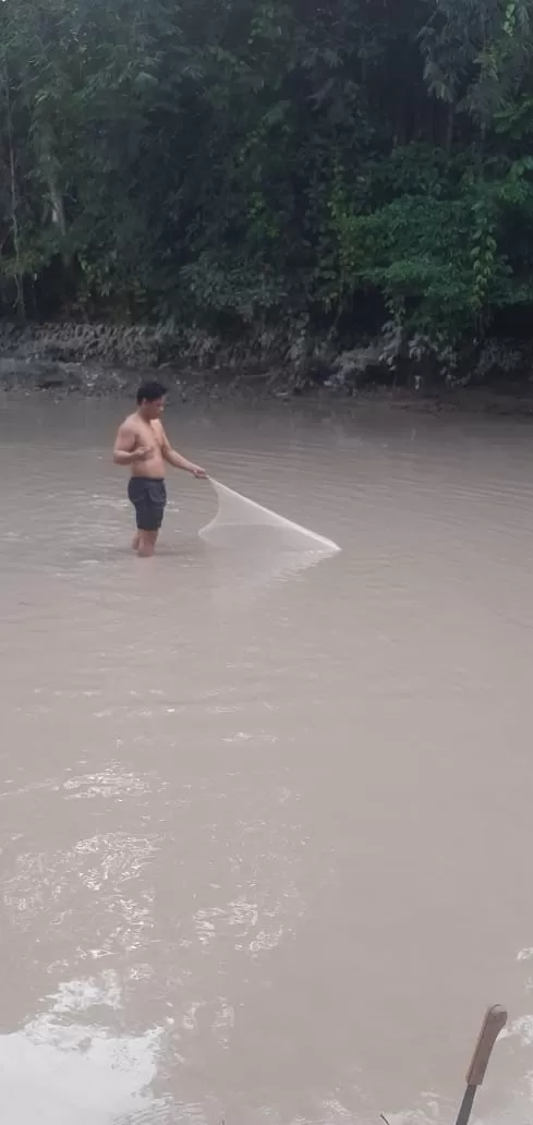 AIR MENGHITAM: Tampak salah seorang warga mencari ikan di sungai yang tercemar akibat limbah perusahaan tambang. FOTO: DOKUMENTASI WARGA