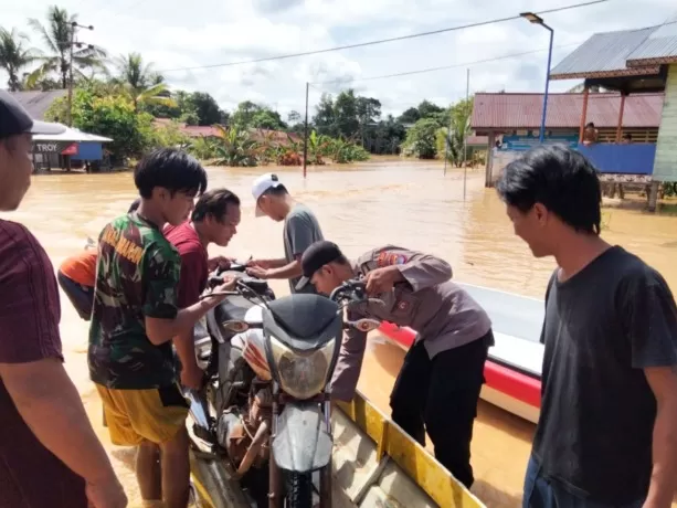DIANGKAT: Tampak kendaraan bermotor milik warga terpaksa diangkut ke perahu lantaran tingginya air membuat jalan tidak dapat dilalui pada banjir di Malinau (22/5). (HADI ARIS ISKANDAR/RADAR TARAKAN)