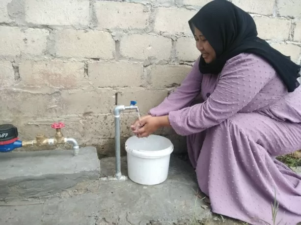 SUDAH TERALIRI AIR: Juliana, salah satu warga RT 18 Juata Permai mulai merasakan aliran air PDAM, Kamis (30/6). (Yedidah Pakondo/Radar Tarakan)