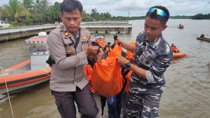 Petugas mengevakuasi jasad korban tenggelam di Desa Teras Baru, Kamis (24/11).