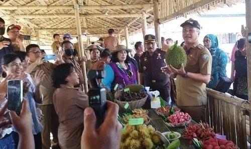 HADI ARIS/RADAR TARAKAN     POTENSI LOKAL: Bupati Malinau Wempi W Mawa SE MH saat mengangkat dan menunjukkan salah satu buah durian saat berkunjung ke salah satu stan buah lokal di Desa Wisata Pulau Sapi.