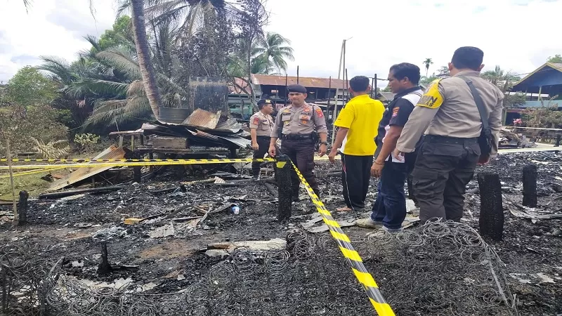 Kapolsek Murung Ipda Yuliantho dan anggotanya melakukan olah TKP peristiwa kebakaran di Desa Muara Sumpoi, Senin (17/2). (DADANG/KALTENG POS)