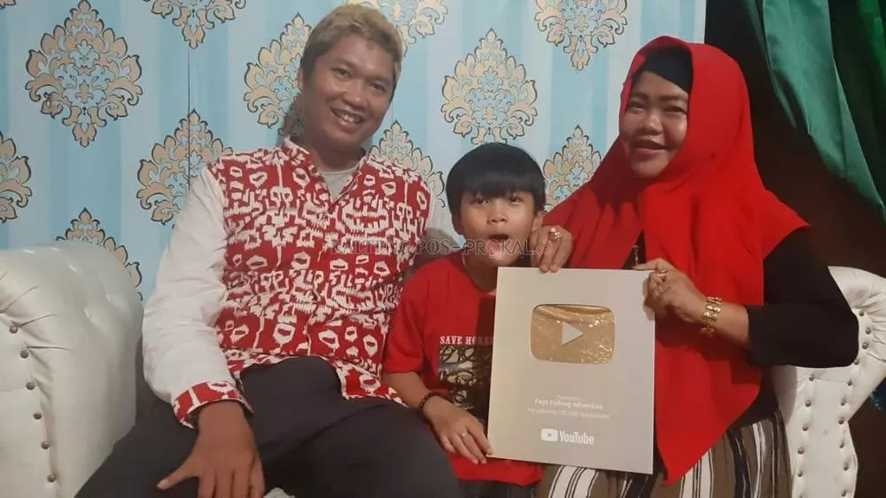 MEMBANGGAKAN: Keluarga Lindu Anugraha Putra memperlihatkan penghargaan silver play button dari YouTube karena memiliki lebih dari 500 ribu subscriber pada channel YouTube-nya. RUSLAN/ KALTENG POS