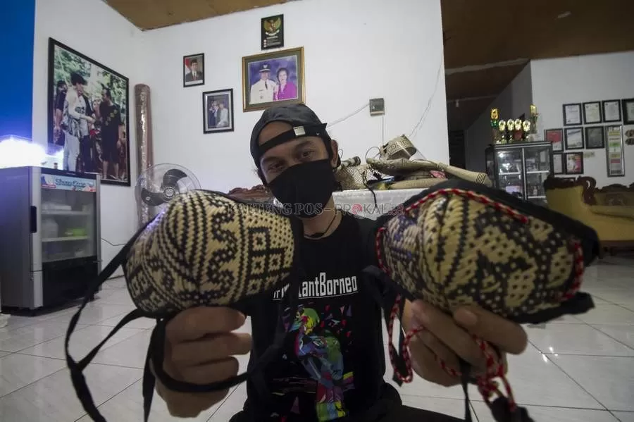 BUAH KREATIVITAS: Benny M Tundan menunjukkan masker bermotif kearifan lokal. DENAR/KALTENG POS