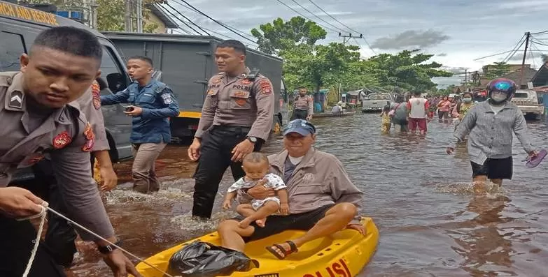 Warga di Jalan Mendawai, Kota Palangka Raya saat melewati debit air banjir yang kian naik, Senin (15/11/2021). (FOTO SYAHYUDI/PROKALTENG)